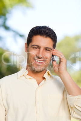 Handsome man phoning in the park