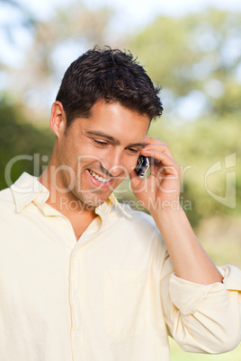 Handsome man phoning in the park