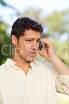 Handsome man phoning in the park