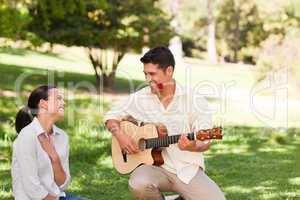 Man playing guitar for his girlfriend