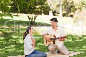 Man playing guitar for his girlfriend