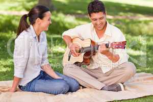 Romantic man playing guitar for his wife