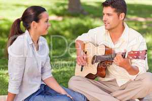 Romantic man playing guitar for his wife