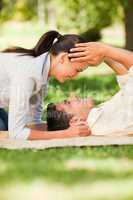 Happy couple lying down in the park