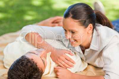 Happy couple lying down in the park