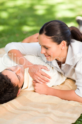 Happy couple lying down in the park