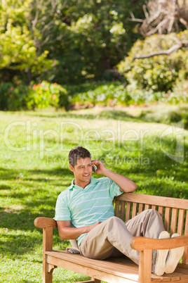 Man with his phone on the bench