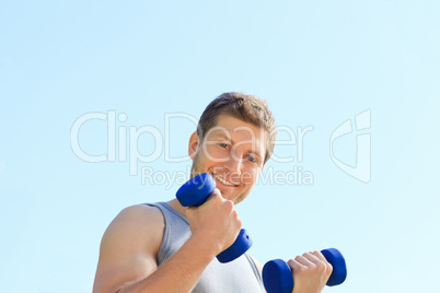 Young man doing his exercises in the park