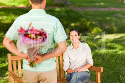 Young man offering flowers to his wife