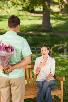 Young man offering flowers to his wife