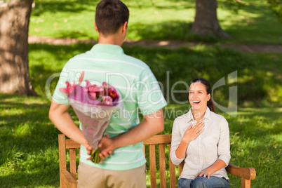 Young man offering flowers to his wife