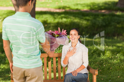 Young man offering flowers to his wife