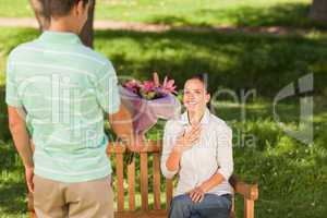 Young man offering flowers to his wife