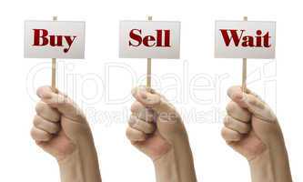 Three Signs In Fists Saying Buy, Sell and Wait
