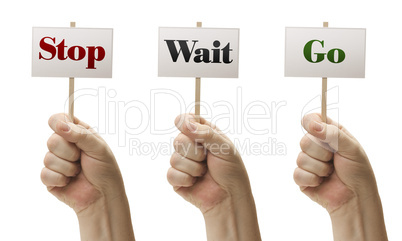 Three Signs In Fists Saying Stop, Wait and Go