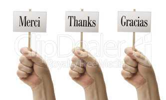 Three Signs In Fists Saying Merci, Thanks and Gracias