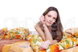 Young woman lay on color pillow and look at you