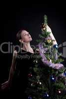 Young woman decorate christmas tree