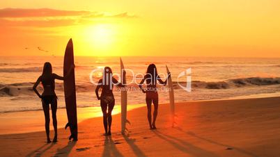 Surferinnen bei Sonnenuntergang