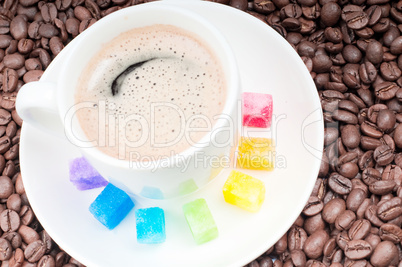 Multicolored slabs of shugar and cup of coffee