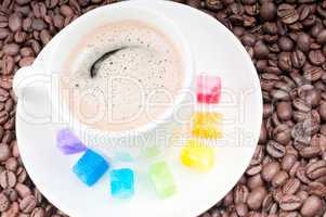 Multicolored slabs of shugar and cup of coffee