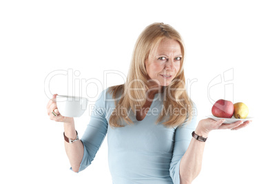 Middle aged woman with cup and fruits