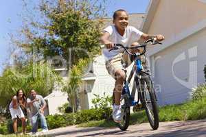 African American Family WIth Boy Riding Bike & Happy Parents