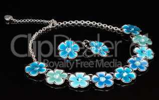 A blue necklace with flowers