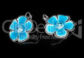 A pair of blue earrings with flowers