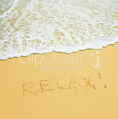 relax written in a sandy tropical beach