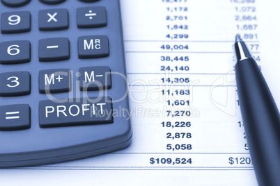 profit button on calculator, pen and finance report