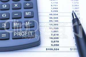 profit button on calculator, pen and finance report
