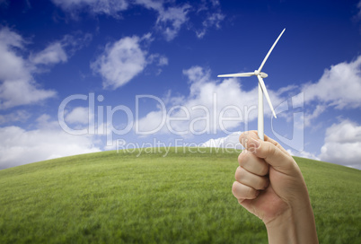 Male Fist Holding Wind Turbine Outside with Grass Field