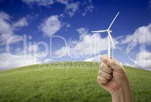 Male Fist Holding Wind Turbine Outside with Grass Field