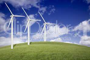 Three Wind Turbines Over Grass Field and Blue Sky