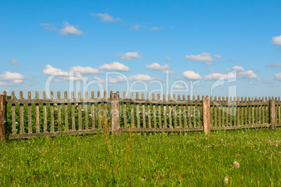 Blue sky, green grass and fence