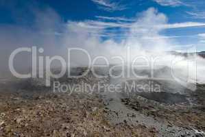 mud geyser over blue sky, altiplano, bolivia