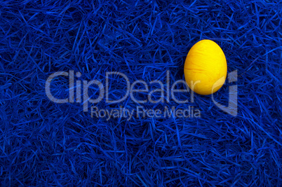 Yellow easter egg on dark blue background