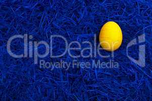 Yellow easter egg on dark blue background