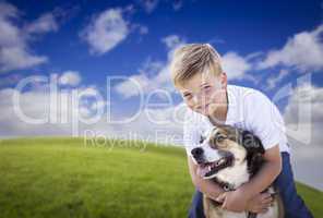 Handsome Young Boy Playing with His Dog in the Grass