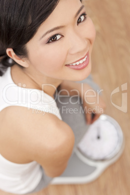 Oriental Asian Chinese Woman Weighing Herself on Scales at Gym