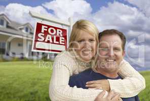 Happy Couple Hugging in Front of Real Estate Sign and House