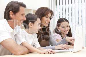 Family Sitting Using Laptop Computer At Home