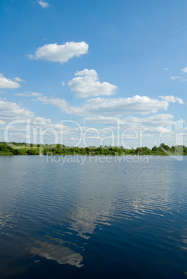 bank of the river, green grass and blue sky