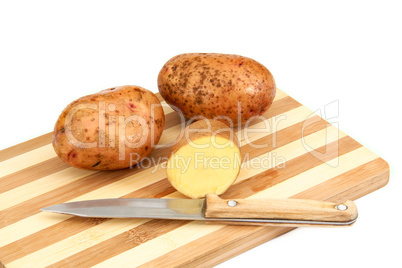 Raw potato tubers lying on a cutting board