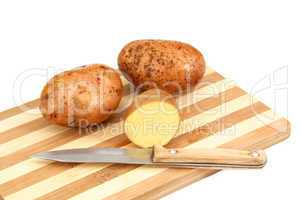 Raw potato tubers lying on a cutting board