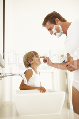 Mann rasiert sich mit Sohn