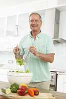 Mann bereitet Salat zu