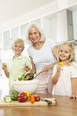 Familie bereitet Salat zu