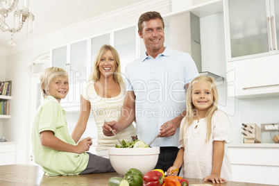 Familie bereitet Salat zu